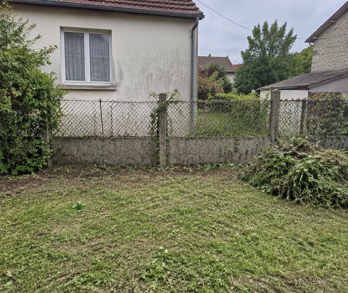 Le même terrain après débroussaillage, clôture dégagée et herbe coupée